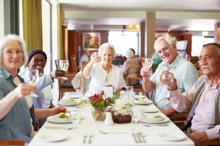 A group of senior individuals joyfully celebrating together at a restaurant, sharing laughter and smiles.