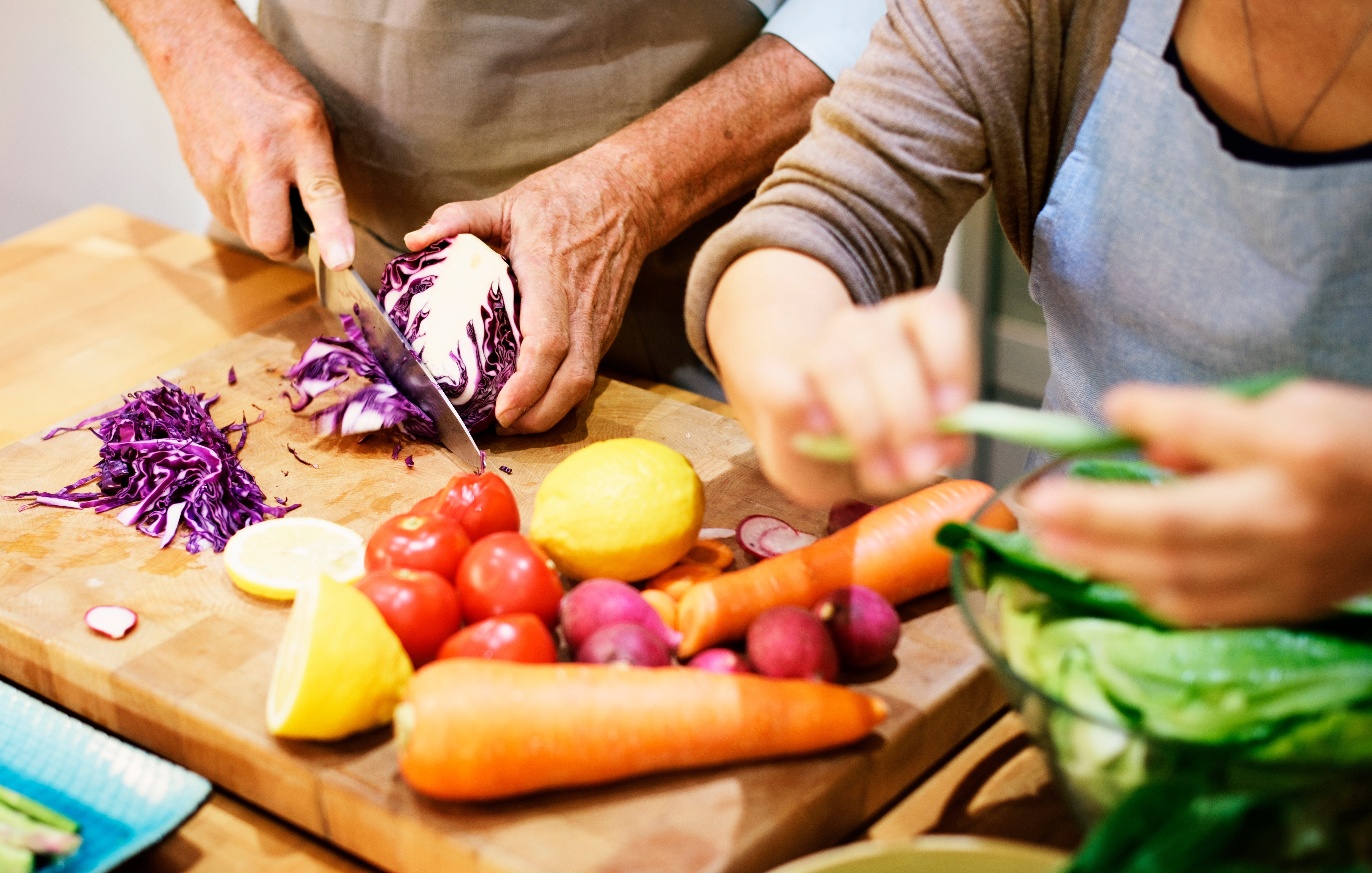 Two adults cutting vegetables