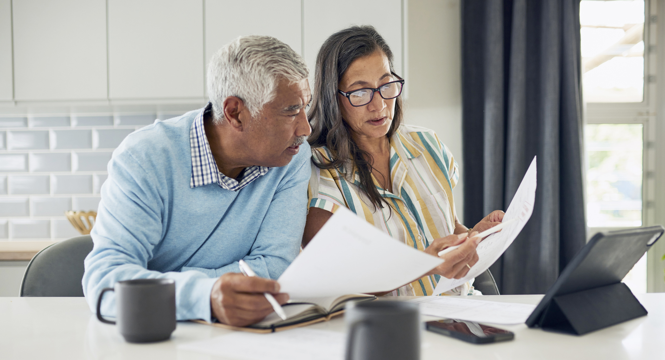 Older adults, a woman and man, looking intently at a laptop screen