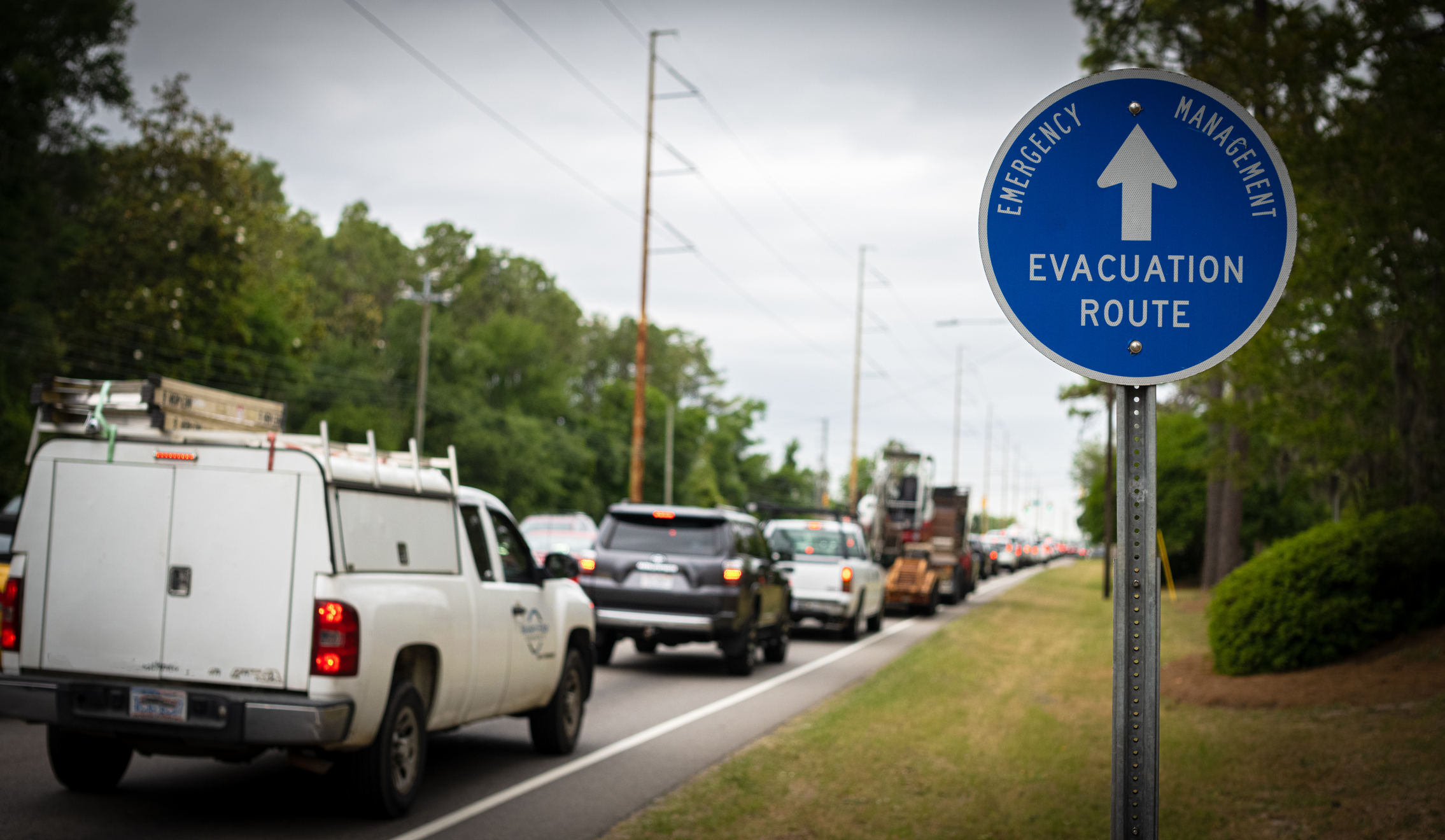 Image of a line of cars and a sign that reads evacuation route.